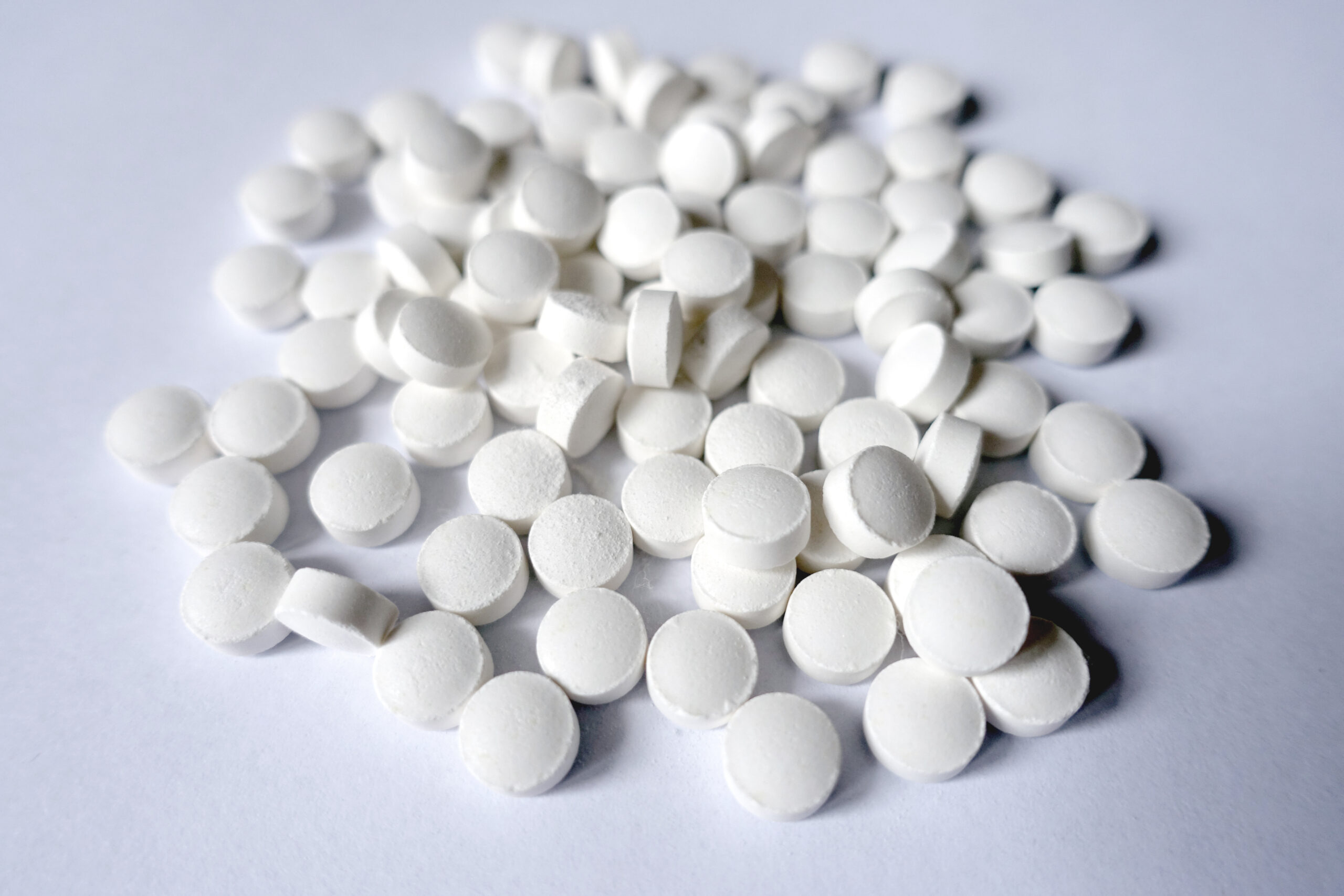 Big heap of white tablets of vitamin K2