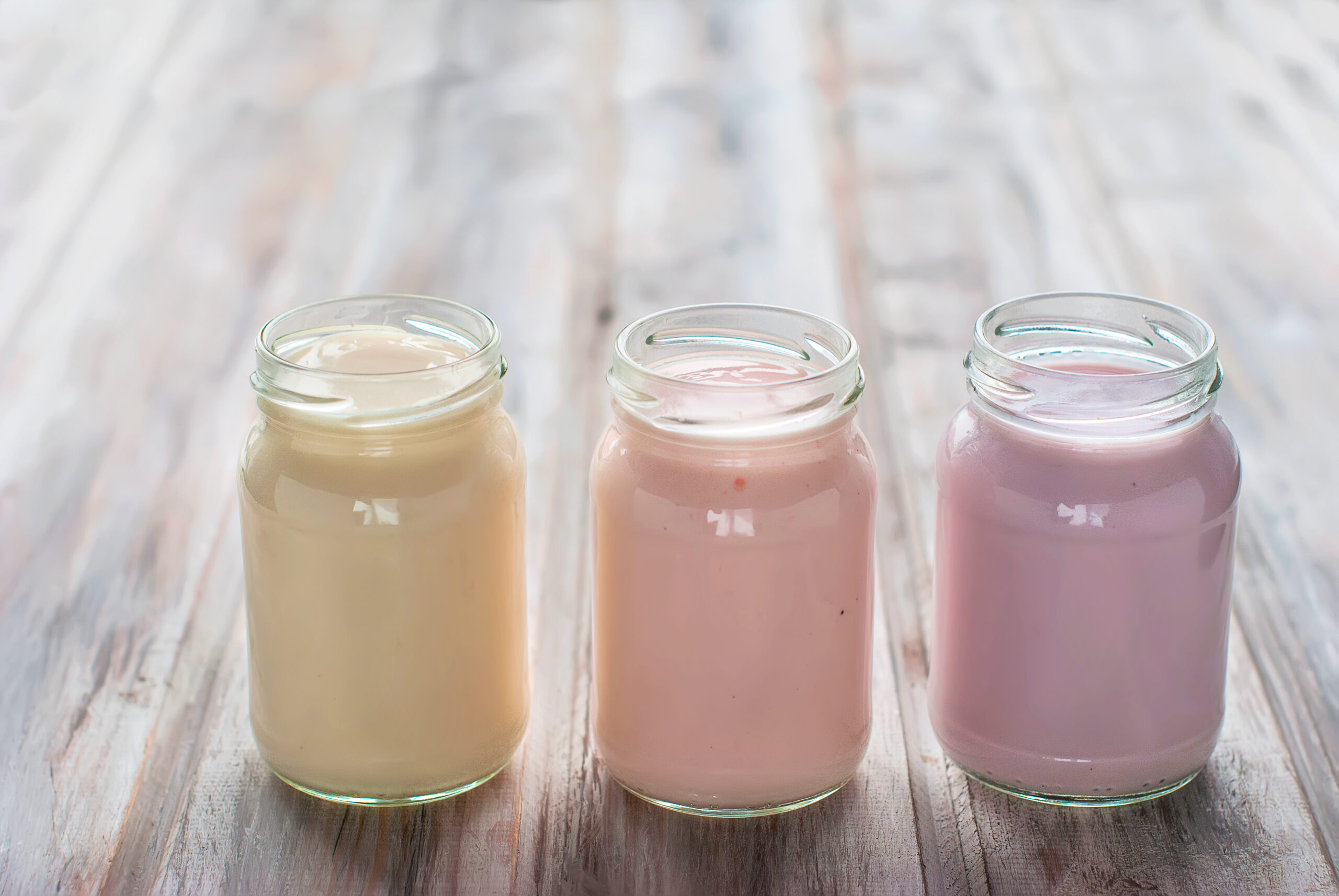 jars with fruit yogurt on a wooden table