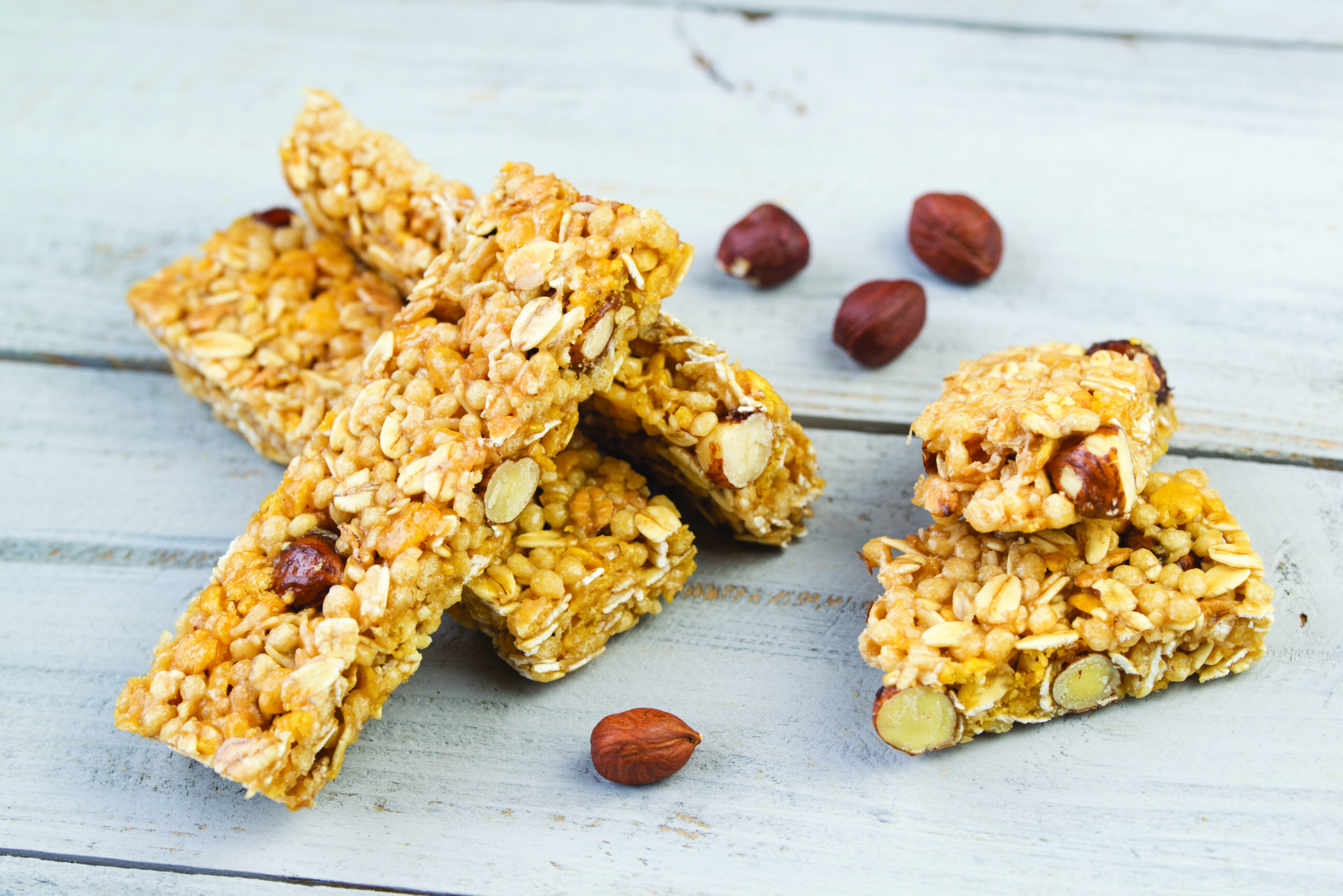 Homemade granola bars with roasted nuts, selective focus, wooden background